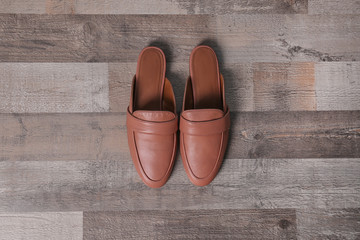 Pair of female shoes on wooden background, top view