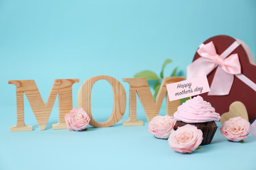 Festive surprise with tasty treat for Mother's Day on color background