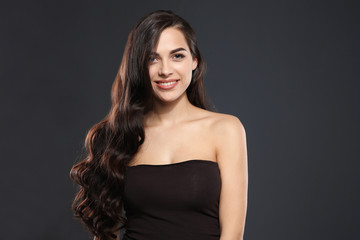 Naklejka premium Portrait of beautiful model with gorgeous curly hair on black background