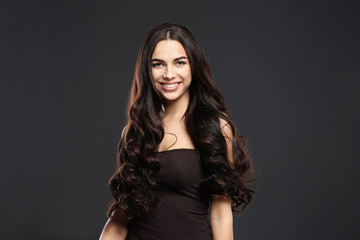 Naklejka premium Portrait of beautiful model with gorgeous curly hair on black background