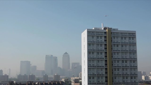UK May 2018 - Passenger jet planes pass over Canary Wharf financial district which is shrouded in smog as London suffers a &ldquo;Code Red&rdquo; air pollution warning.