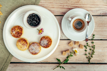 breakfast with four cheese pancakes, black coffee and currant jam