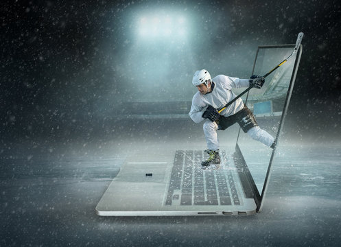 Caucassian ice hockey Players in dynamic action in a professional sport game play on the laptop in hockey under stadium lights.