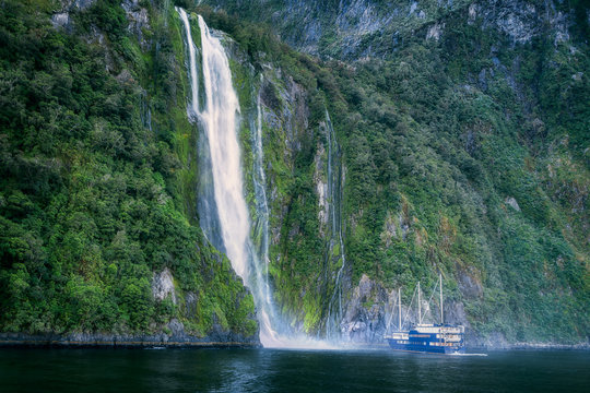 A Cruise boat in front of Stirling Falls at Milford Sound, New Zealand, South Island.