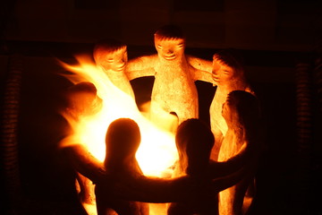 Candlestick in the form of embracing little men, burning fire