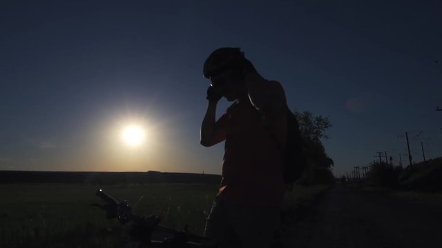 A young man is actively spending time on his bike at sunset. A bike ride in the sunset