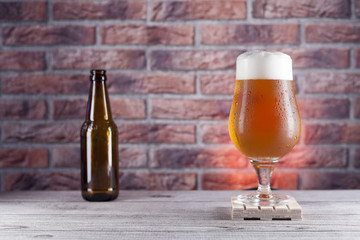 glass and bottle of beer on red