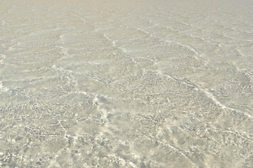 Sand beach, coastline and crystalline clear water in sea.