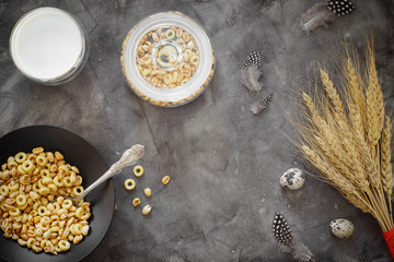 Flakes for breakfast and a glass of milk on a table with wheat and quail eggs