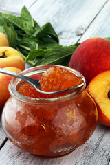 Peach vanilla jam with fresh peaches on table.