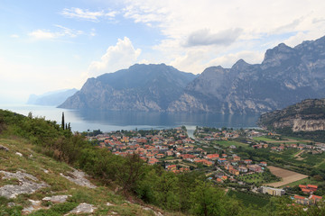Panorama of Lake Garda, lakeside village Torbole and mountains, Italy