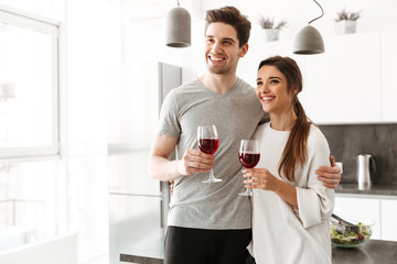Portrait of a happy young couple holding glasses of wine