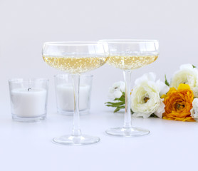 Two glasses of champagne with flowers and candles