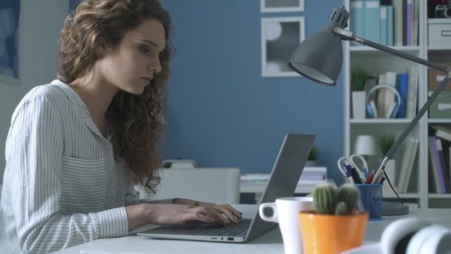 Young woman working with her laptop and having headache