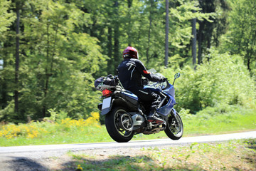 Obraz premium Motorradfahrer auf einer kurvenreichen Landstraße 