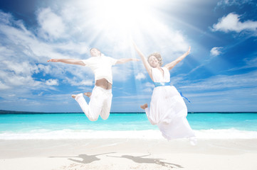 Wedding couple jumping on the beach