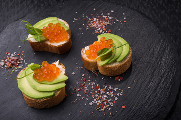 Tasty bruschetta with avocado and caviar