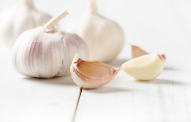 Garlic on white wood background.