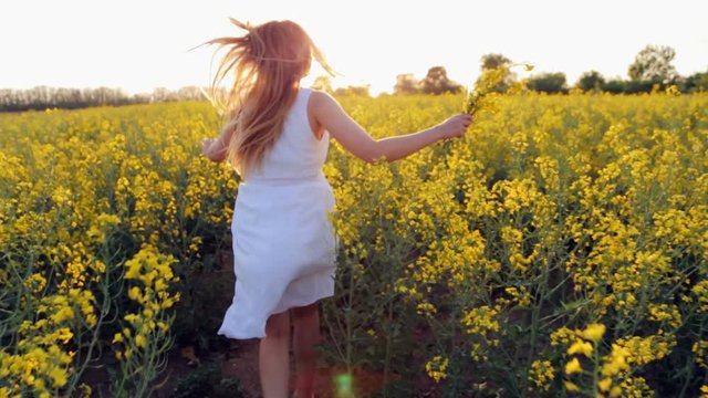 The girl runs on the flower field