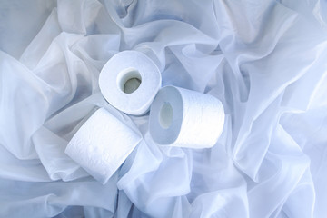 White toilet paper rolls on drapery cloth. Top view, Closeup. Copy space.