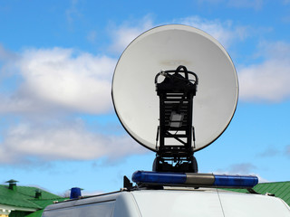 Satellite dish antennas with sky, police car
