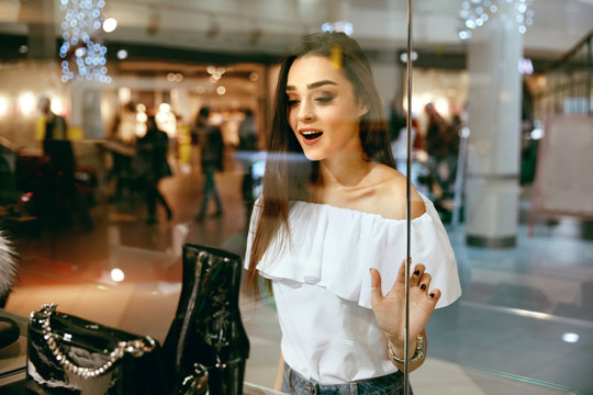 Young Woman Looking Through Shop Window