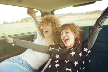 Dos amigas pasándoselo bien mientras van en coche 