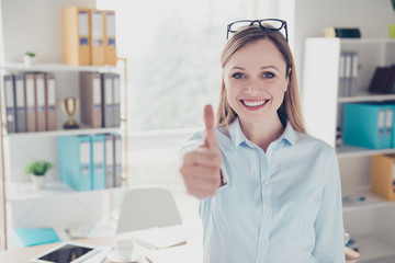 Portrait of charming, nice, confident, positive woman with glasses on head making thumb up, like...