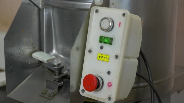 The man presses the button to turn on the potato cleaner