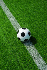 Fussball auf der Linie, klassisch schwarz weiss, grüner Kunstrasen im Sommer draussen