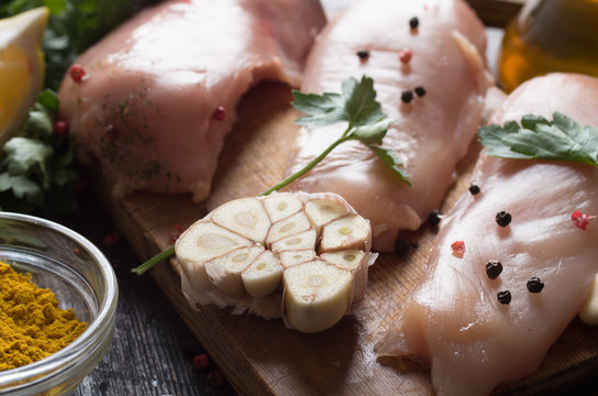 Raw chicken meat on wooden board on table