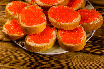 Naklejka na ściany i meble Sandwiches with red caviar on wooden table