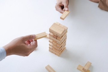 close up of business people holding wooden block, risk and strategy concept