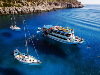 Aerial shot of beautiful blue lagoon at hot summer day with sailing boat. Top view of people are...