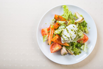 Fresh salad with poached egg, meat, tomato