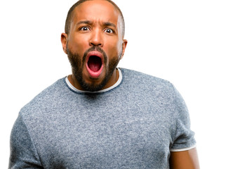 African american man with beard scared and surprised cheering expressing wow gesture. Unbelieving isolated over white background