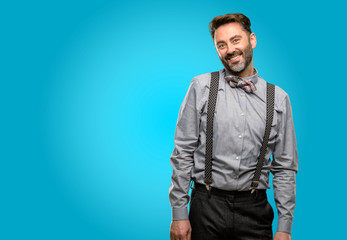 Middle age man, with beard and bow tie confident and happy with a big natural smile laughing, natural expression