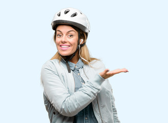 Young woman with bike helmet and earphones holding something in empty hand