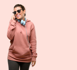 Young sport woman with headphones and sunglasses holds hands welcoming in handshake pose, expressing trust and success concept, greeting