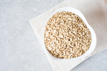 Food. Dry rolled oat flakes oatmeal on bowl. Healthy eating concept.