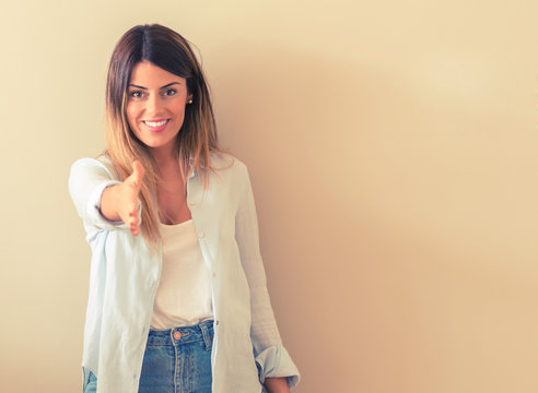 Vintage photo of a Beautiful woman against wall holds hands welcoming in handshake pose, expressing trust and success concept, greeting