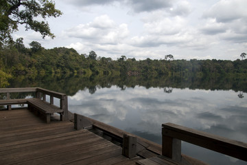 Fototapeta premium Banlung Cambodia, view of Yeak Lom lake from wooden pier with reflection of sky in water