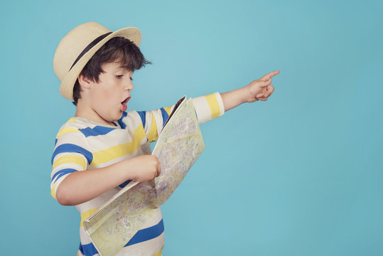 ni&ntilde;o con sombrero y mapa sobre fondo azul