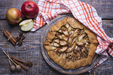 Home-made baking - a pie, a biscuit with apples on a wooden board, background