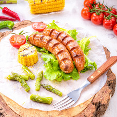 grilled krakauer sausage with boiled corn and green salad