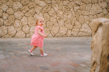 Little cute blonde baby girl infant running