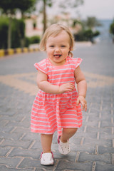 Fototapeta premium Little cute blonde baby girl infant running and smiling
