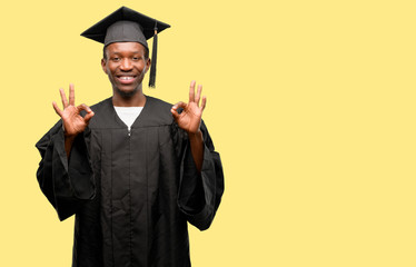 Young african graduate student black man doing ok sign gesture with both hands expressing meditation and relaxation