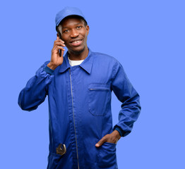 African black plumber man happy talking using a smartphone mobile phone