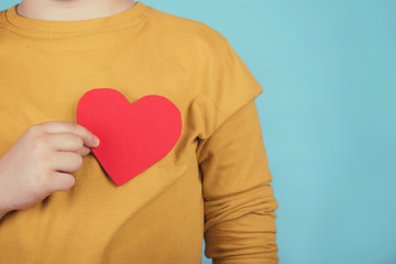 niño con un corazón sobre fondo azul